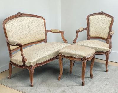 two chairs and a ottoman in the corner of a room