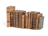 many old books lined up in a row on a white surface