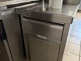 a silver dishwasher sitting on a counter in a kitchen