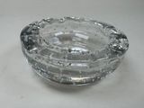 a glass ashtray on a table with water in it