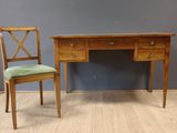 une photo d'un bureau en bois avec une chaise à côté
