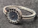 une bague en argent sur laquelle est posée une montre, posée sur une table