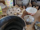 de nombreux vases et bols sont posés sur la table dans cette pièce