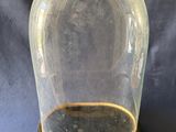 une image représentant une cloche en verre reposant sur un socle en bois