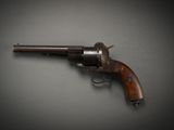 a close up of a gun on a table with a black background