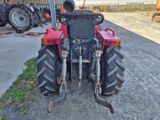 a red tractor that is parked on the side of the road