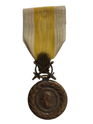 l'image d'une médaille ornée d'un ruban doré sur fond blanc