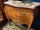 une petite table sur laquelle se trouve un vase, dans une pièce