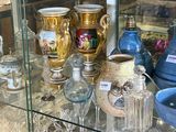 une vitrine en verre dans laquelle sont exposés de nombreux vases différents