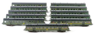 several green train cars are lined up on a white surface