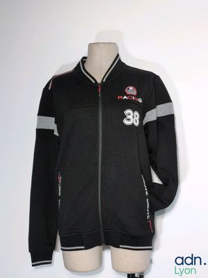 La veste est noire et grise, avec une rayure rouge et blanche.