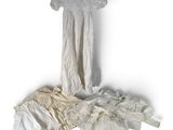 a white dress hanging on a hanger on a white wall