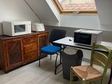 une photo d'une petite pièce avec un micro-ondes et une table