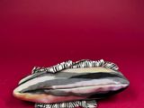 an image of a striped purse sitting on a red surface