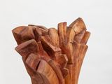 wooden sculpture of a tree trunk on a white pedestal