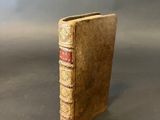 an old book sitting on top of a table on a gray surface