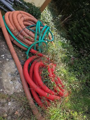 un tas de tuyaux posé par terre à côté d'un bâtiment