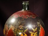 a glass vase with a floral design on it on a purple cloth