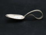 silver spoon with a curved handle on a black surface