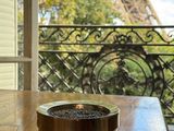 a cup of coffee sitting on a table in front of a window with a view of the eiffel tower