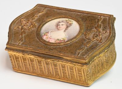 une boîte dorée sur laquelle figure l'image d'une femme
