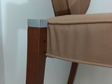 a brown chair with a wooden frame and a beige seat