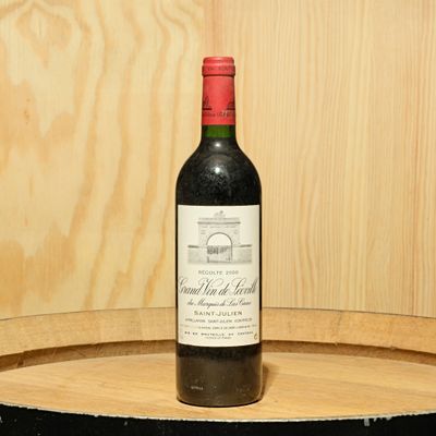 a bottle of wine sitting on top of a barrel