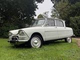 a white car that is parked in the grass