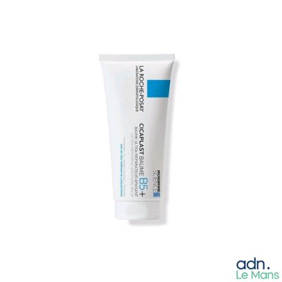 un gros plan d'un tube de dentifrice posé sur une surface blanche