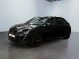 La voiture noire est garée dans une grande pièce aux murs blancs.