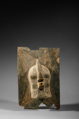 un masque en bois sur lequel figurent un visage et une étoile