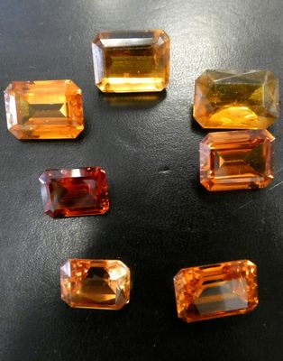 cinq pierres précieuses de couleurs différentes sont disposées sur une surface noire