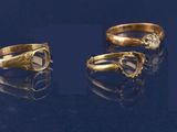 trois types différents de bagues en or serties de diamants sur un fond bleu