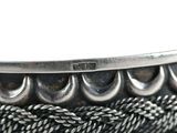 a close up of a silver plate with a rope around it