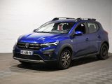 une voiture bleue est garée dans une pièce au sol à carreaux