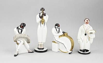 three figurines of men dressed in black and white sitting next to each other
