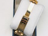 a gold watch in a black box on a white surface