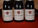 three bottles of wine sitting on top of a red table