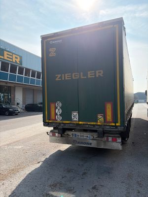 un camion qui roule dans la rue devant un immeuble
