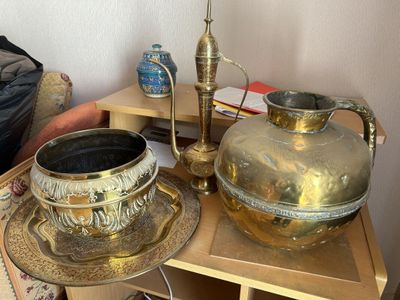 une table sur laquelle se trouvent un vase en or et une assiette en argent