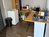a room with a desk and a refrigerator in it