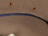 a close up of a hat with a feather on it