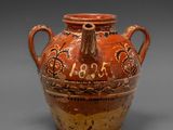 un vase marron et rouge sur lequel figurent des chiffres