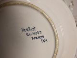 a person holding a white bowl with writing on it