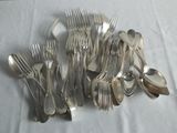 a lot of forks and spoons sitting on a table