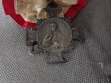 a teddy bear that has a medal on it ' s neck