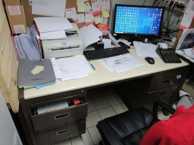 un bureau sur lequel se trouvent un ordinateur, une imprimante et d'autres fournitures de bureau