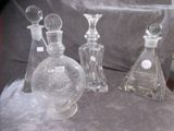 trois flacons de parfum en verre posés les uns à côté des autres sur une table