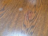 a close up of a wood table with a stain of paint on it