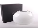 un vase blanc posé à côté d'une boîte sur une surface blanche